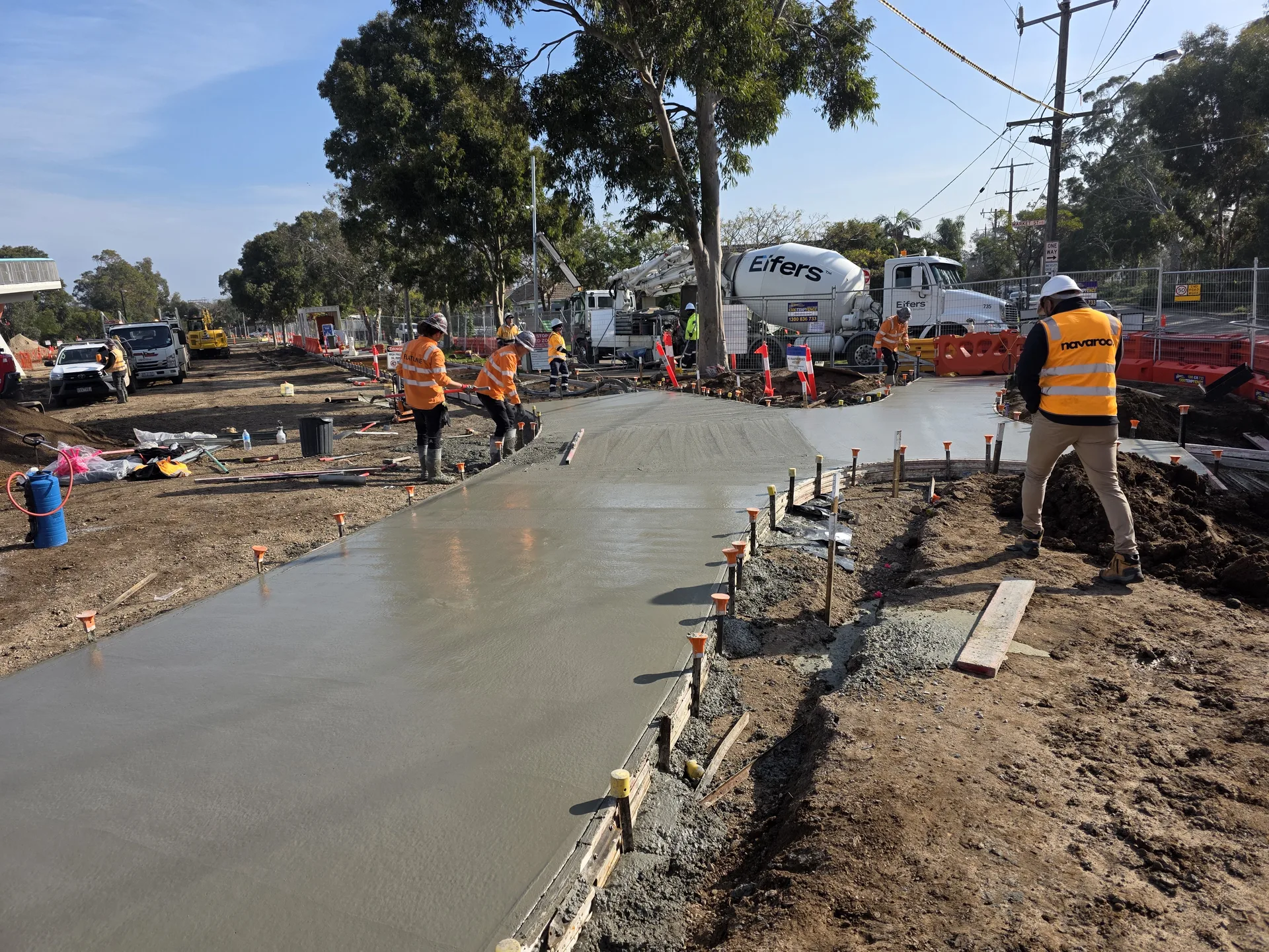 Navaroo crew coordinating concrete placement with plant inside a constrained transport-infrastructure workfront.